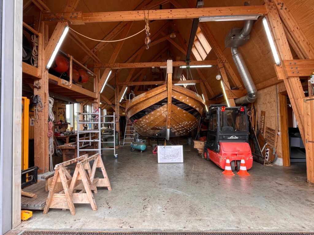 Opgeruimde botterloods van het Bottermuseum Harderwijk met een historische botter centraal in de werkplaats