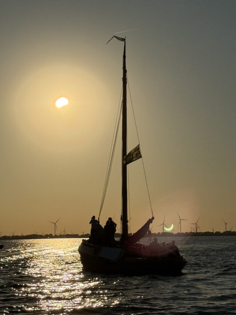 De HK22 of HK23 vaart tijdens de gedeeltelijke zonsverduistering over het Wolderwijd