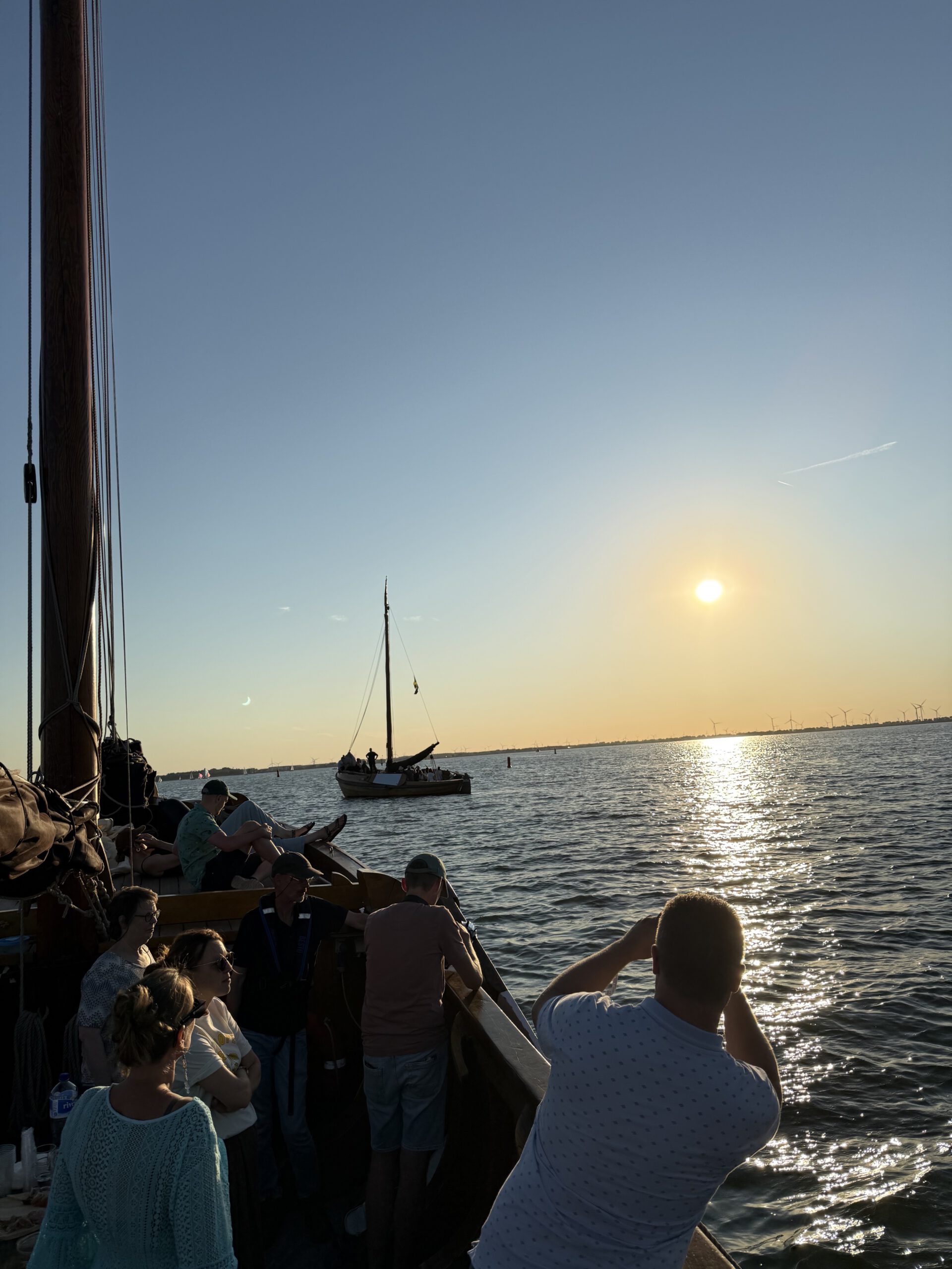 Gasten aan boord kijken vanaf een botter naar de gedeeltelijke zonsverduistering